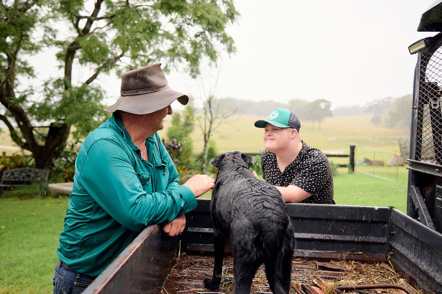 Man, disabled son and dog on the farm