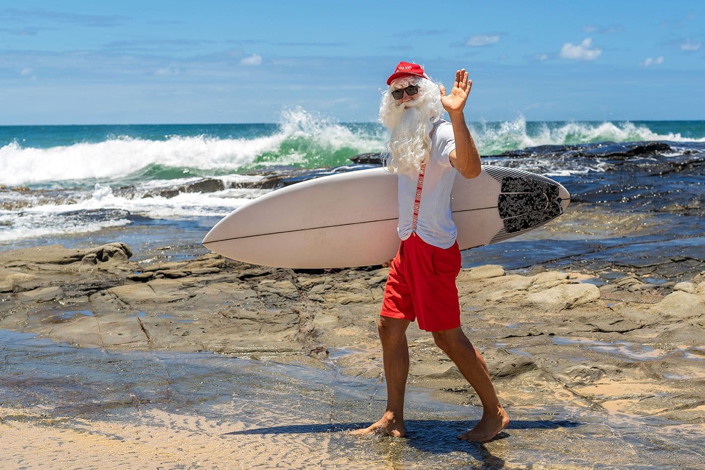Santa about to go surfing at the beach