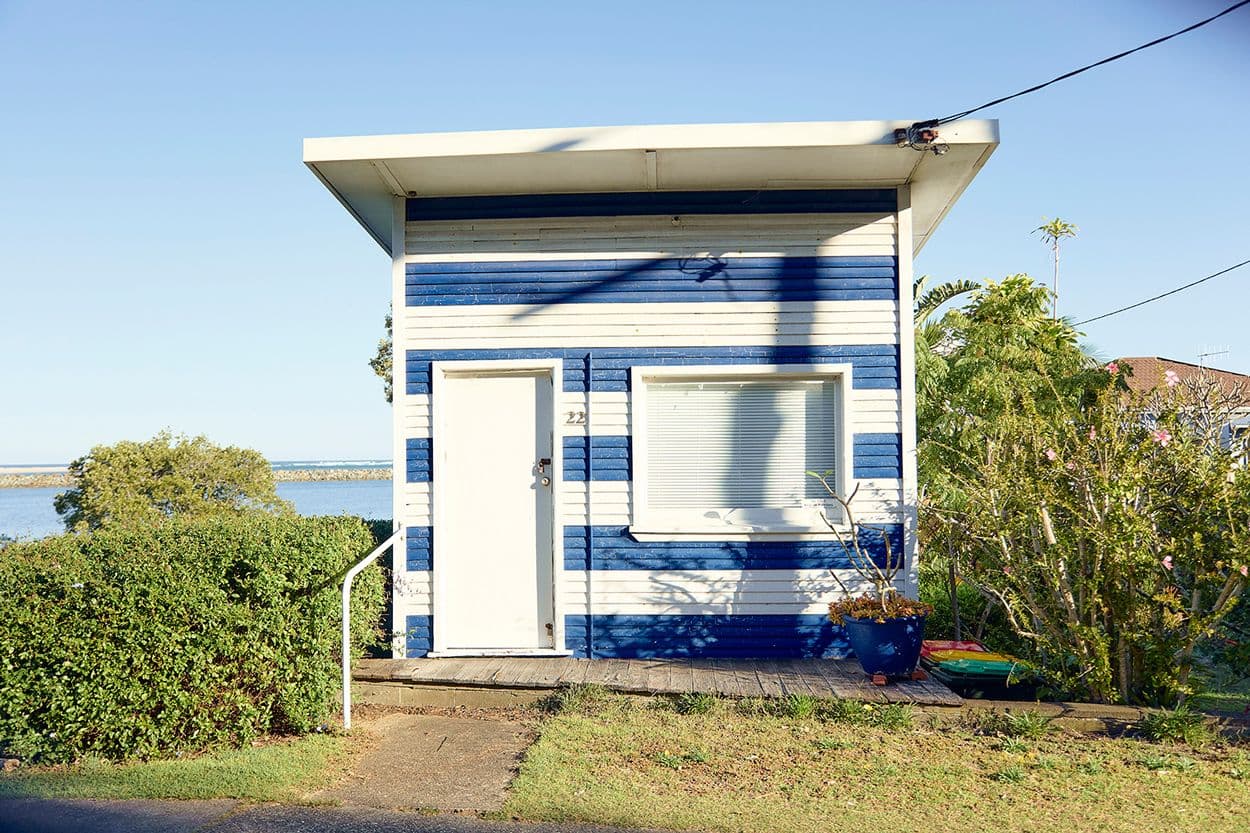 Little blue and white stripped house by the water