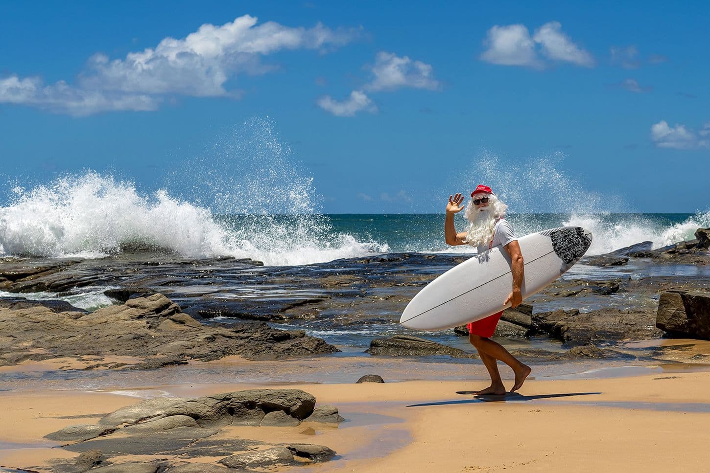 Santa about to go surfing at the beach