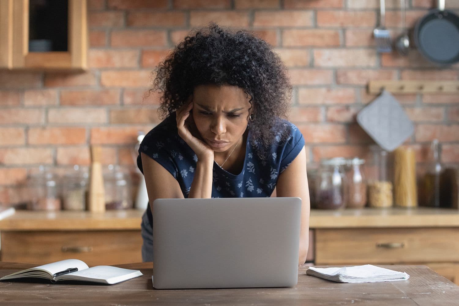 woman looking at her laptop with a concerned look on her face.