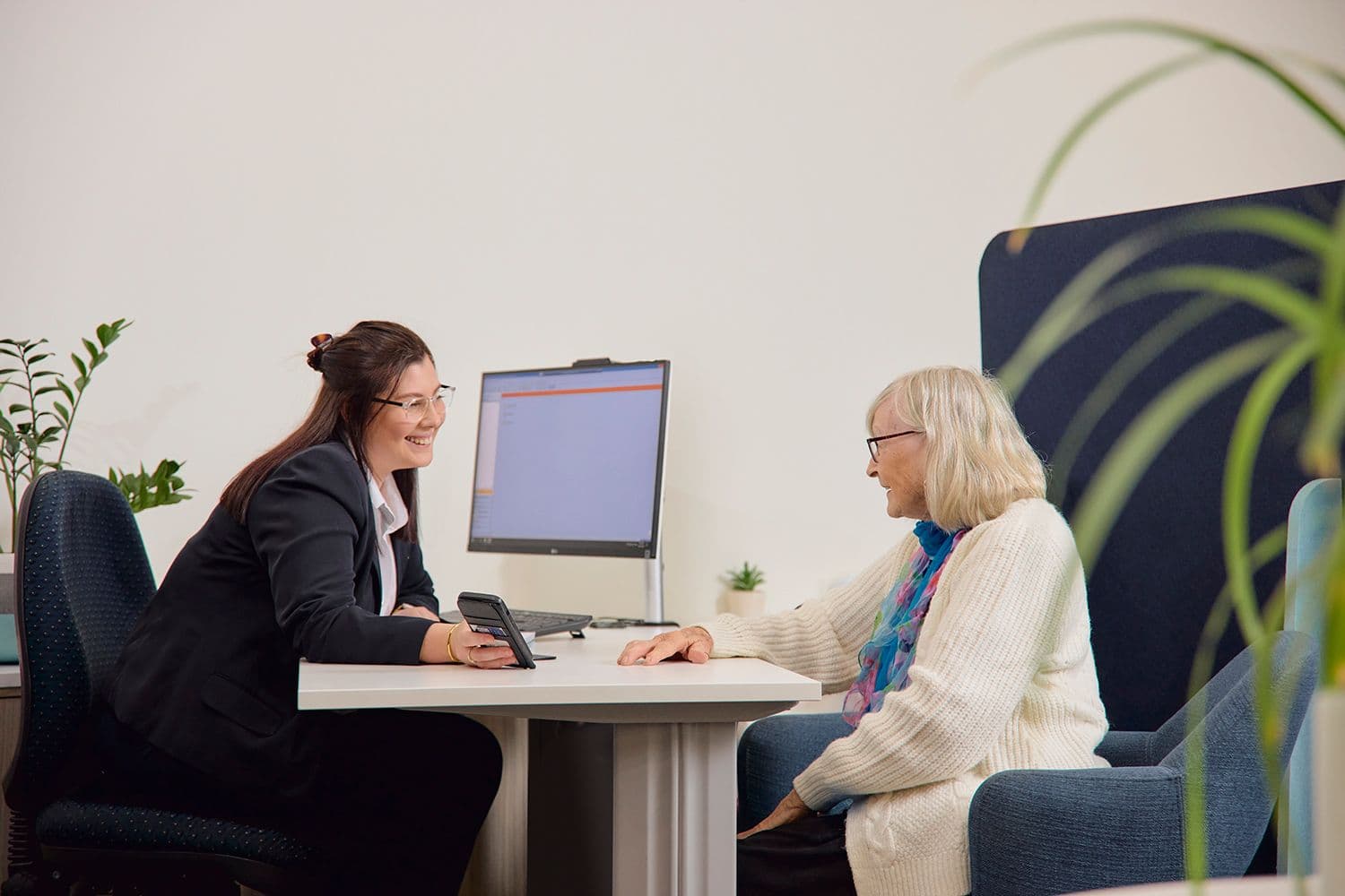 Elderly woman getting advice from a Coastline Bank Customer Service Officer.